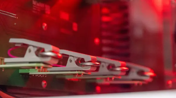 Lithium-ion coin cells in a laboratory testing fixture, photographed in 2026.