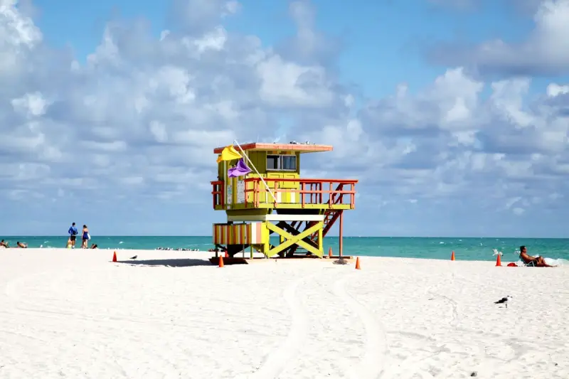 Colorful lifeguard tower on the sand at Miami Beach under a bright sky