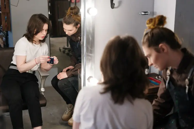 Hairstylist talking through a cut with a client in a modern salon