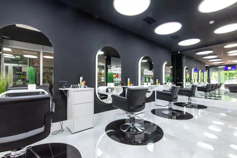 Modern beauty salon with black styling chairs, arched mirrors and round ceiling lights