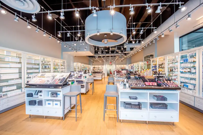 Skincare and makeup displays on white shelving and counters under track lighting