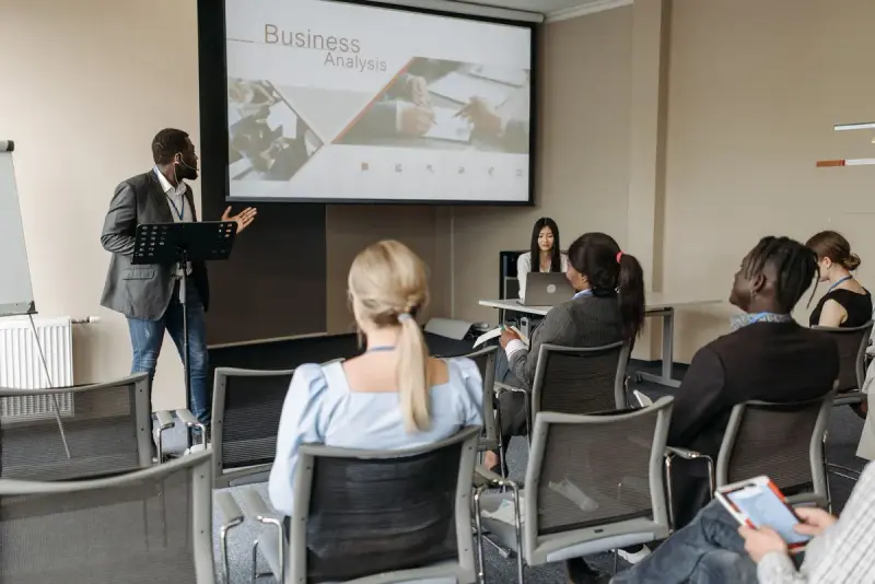 Business seminar with a speaker beside a projection screen