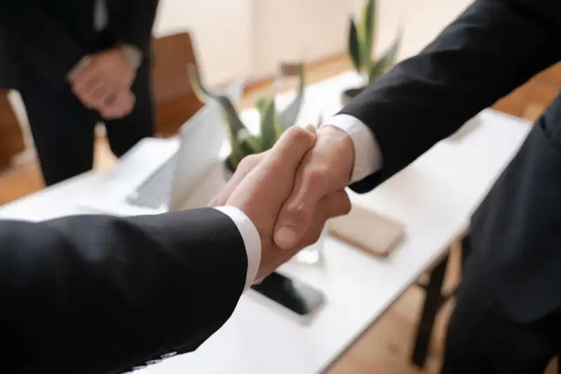 Two professionals shaking hands, photographed in shallow focus