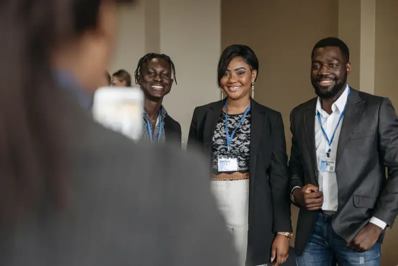 Three professionals smiling together at a corporate event
