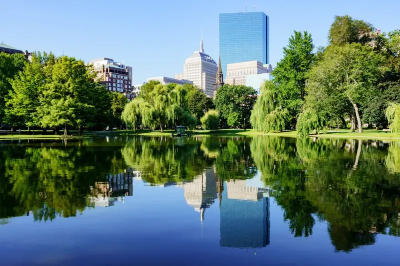 Boston Public Garden pond reflecting the Back Bay skyline on a sunny day