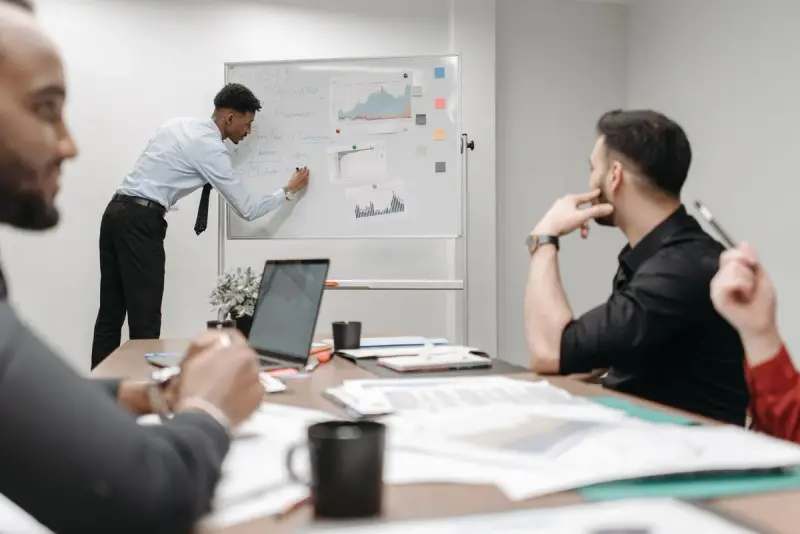 Colleagues in a meeting discussing data and strategy at an office table