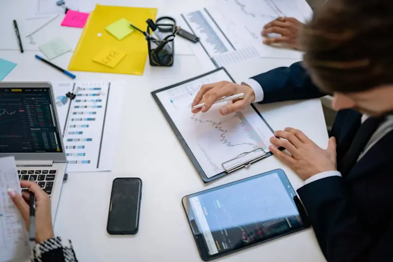 Business team checking financial data on tablets at a table