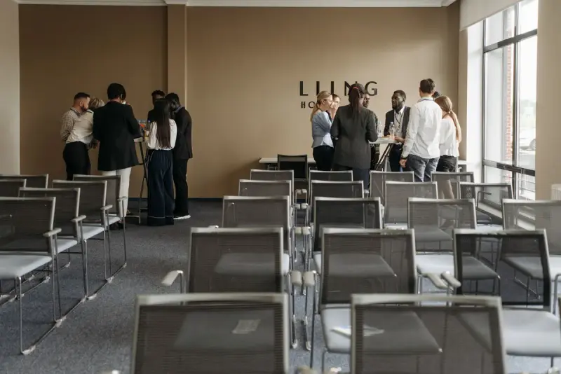 Four professionals wearing name badges in animated discussion at an indoor event
