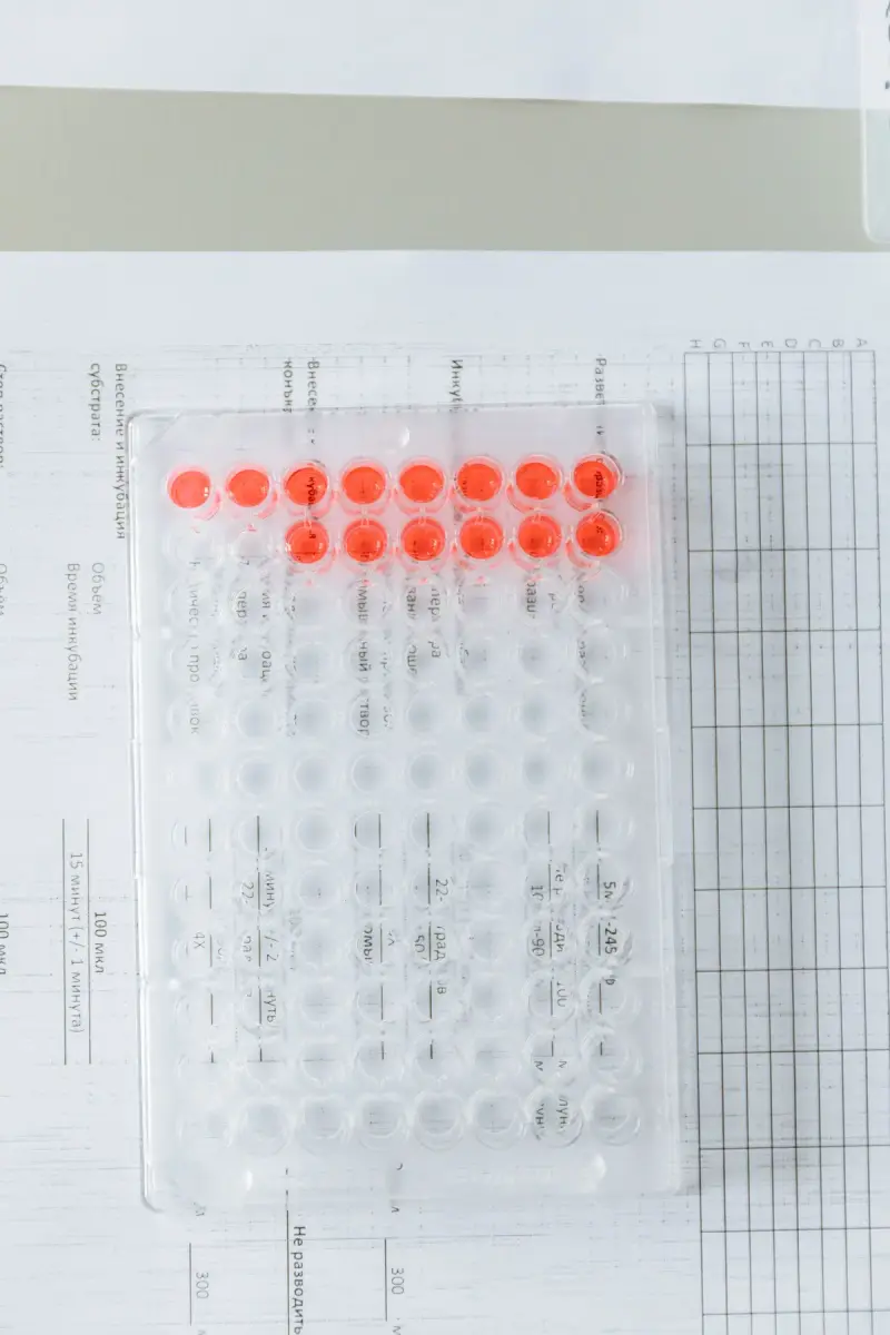 Multiwell plate with a row of red samples on a lab worksheet