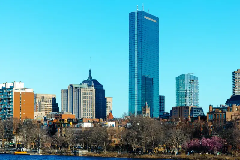 Back Bay skyline with the John Hancock Tower above the Charles River under blue sky