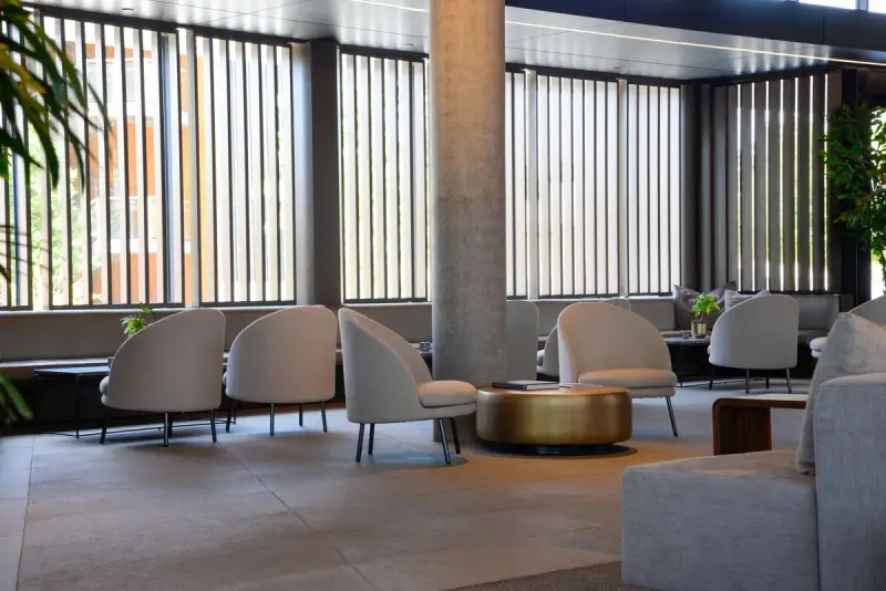 Bright hotel lounge with curved armchairs and tall windows