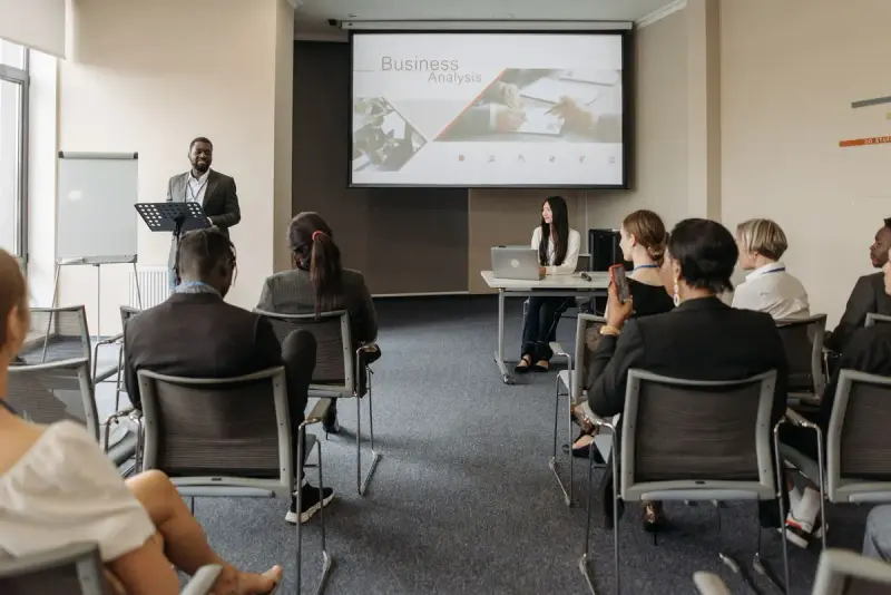 Man speaking to a seated audience in a conference room
