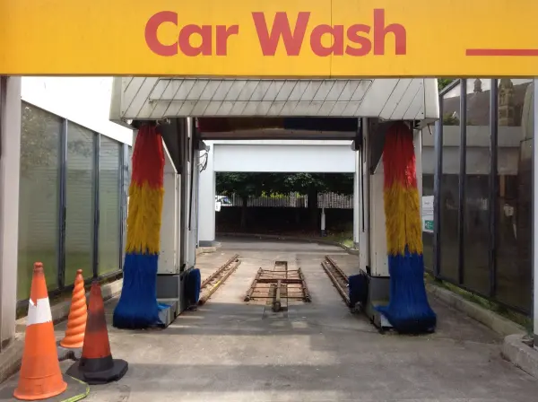 Automatic car-wash entrance with colorful brushes and traffic cones