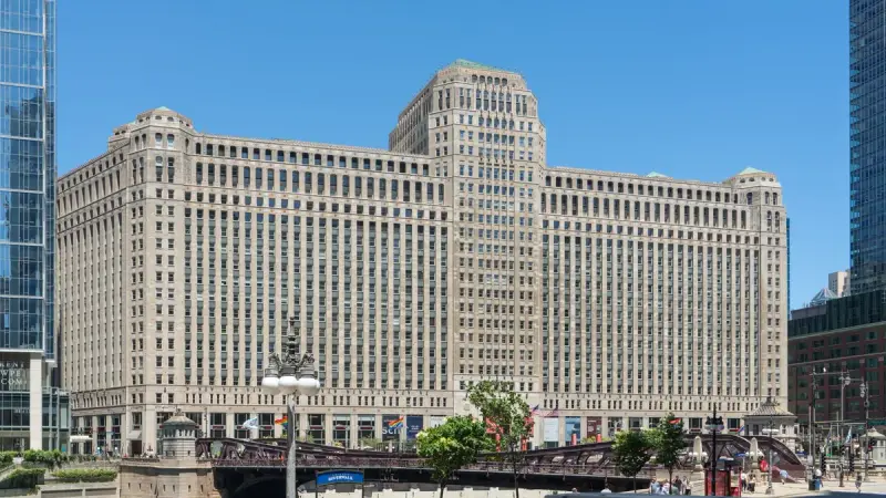 The Merchandise Mart (THE MART) building in daylight beside the Chicago River