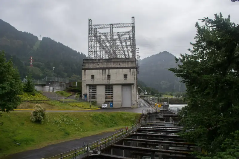 Hydroelectric powerhouse with a stepped fish ladder alongside it