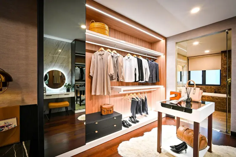 Dressing room with lit hanging rods, a glass-top island and a vanity mirror