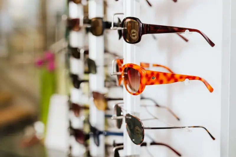 Rows of sunglasses on a retail display rack