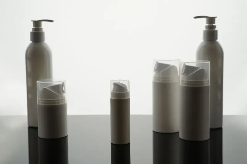 Empty white cosmetic bottles and jars arranged for a packaging display
