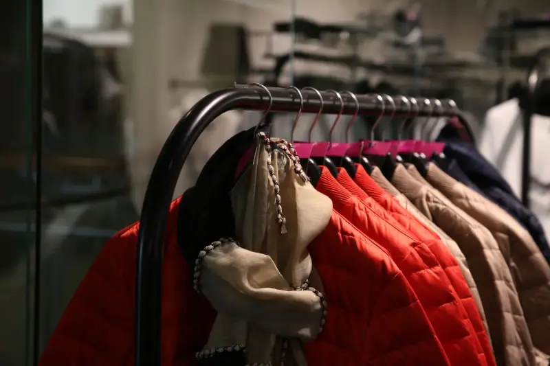 Red quilted jackets and coats on a black rack in a shop