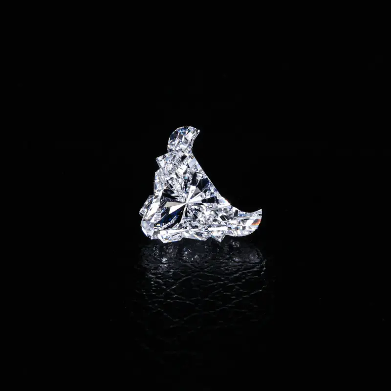 Fancy-shape diamond standing on a dark reflective surface