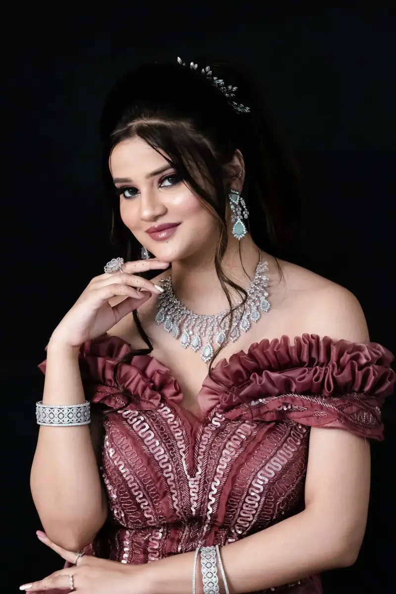 Woman in a ruffled rose gown wearing a diamond necklace, earrings and bangles