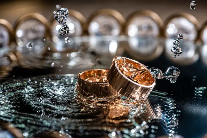 Gold rings with water splashing around them