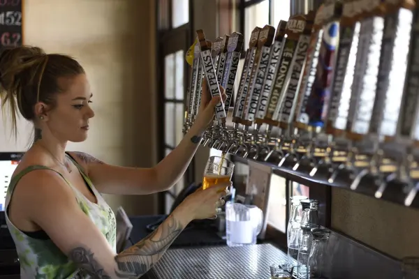 Woman pouring beer from a tap into a glass