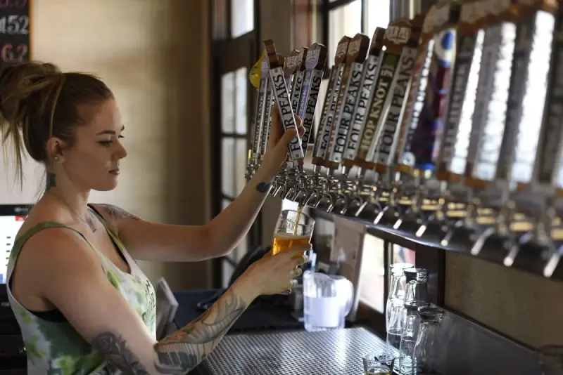 Woman pouring beer from a tap into a glass
