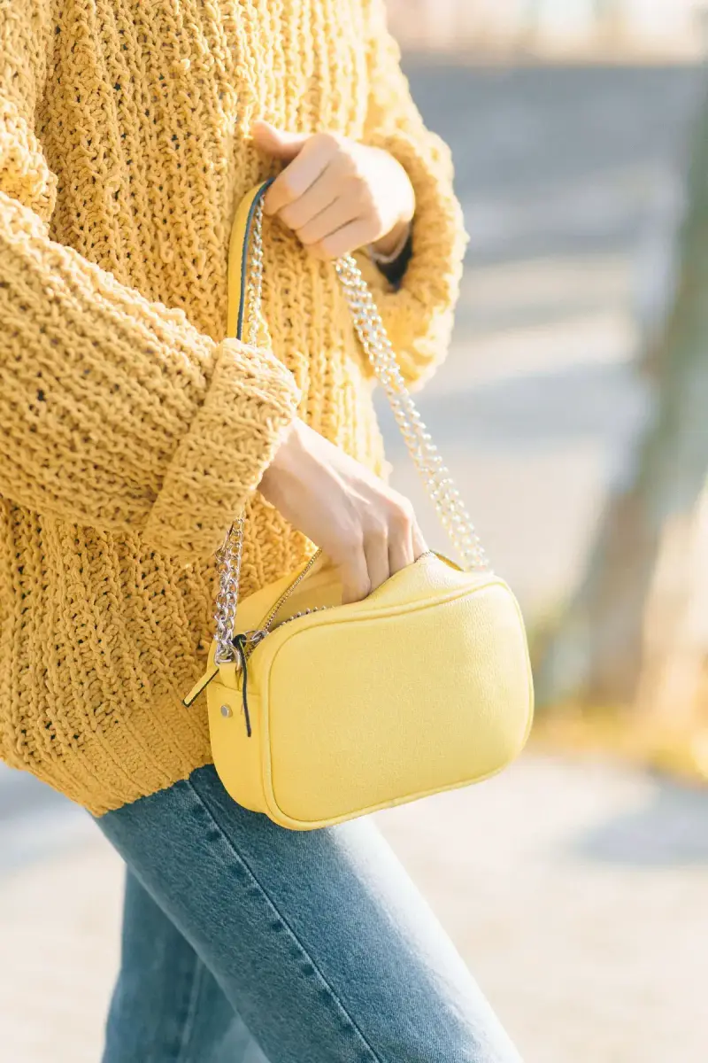Mustard chunky-knit sweater with a lemon leather crossbody bag on a chain strap