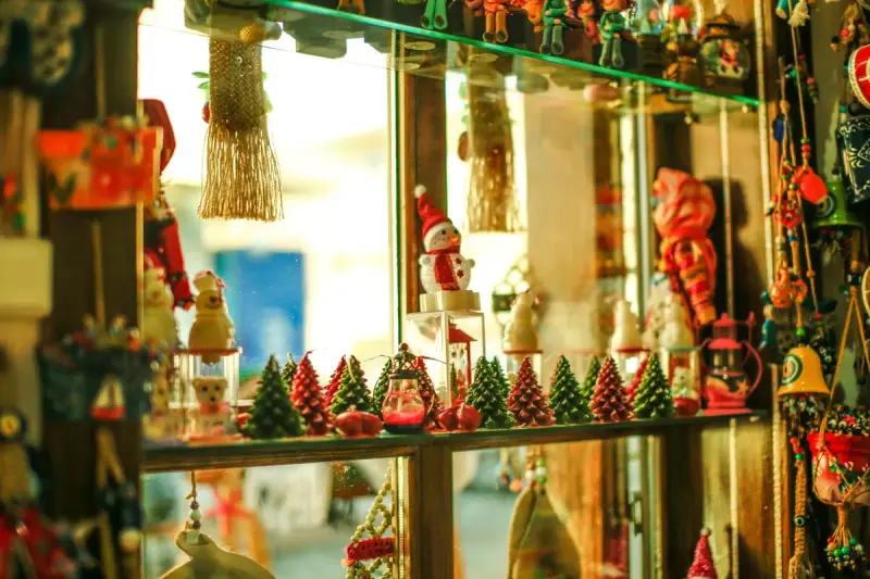 Shop window shelves crowded with Christmas trees, snowmen, ornaments and holiday figurines