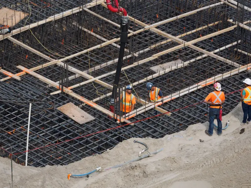 High angle view of workers tying rebar for a building foundation