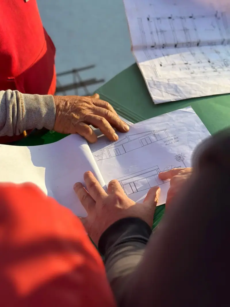 Team of architects examining blueprints together at an outdoor construction site