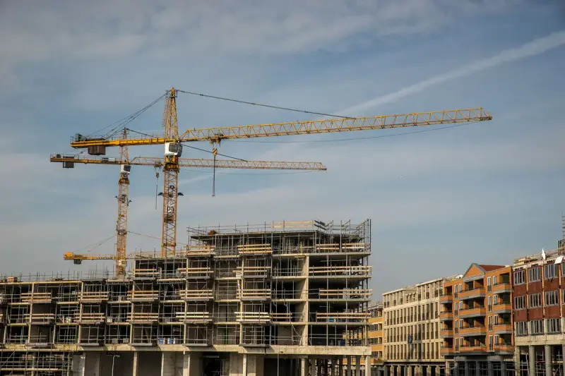 City construction site with tower cranes over partly built concrete structures