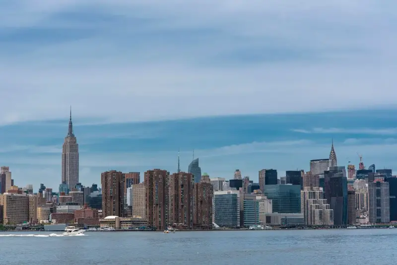 Midtown Manhattan skyline across the river with the Empire State Building at center