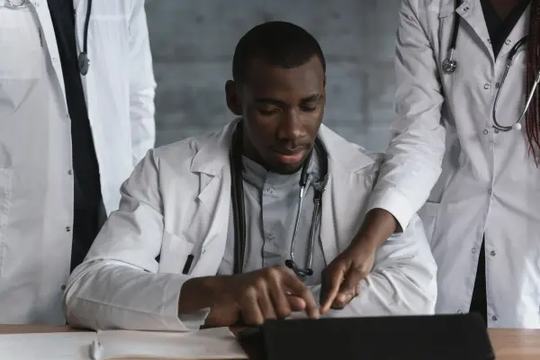 Medical professionals discussing information together at a table.