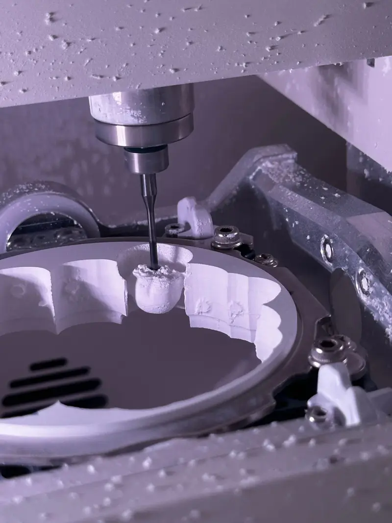 CNC milling machine cutting a metal component with coolant on the tool