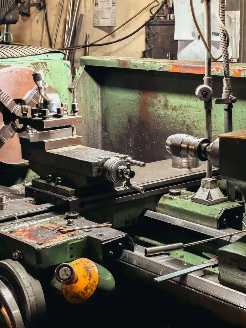 Metal lathe with chuck and tool post in a machine shop