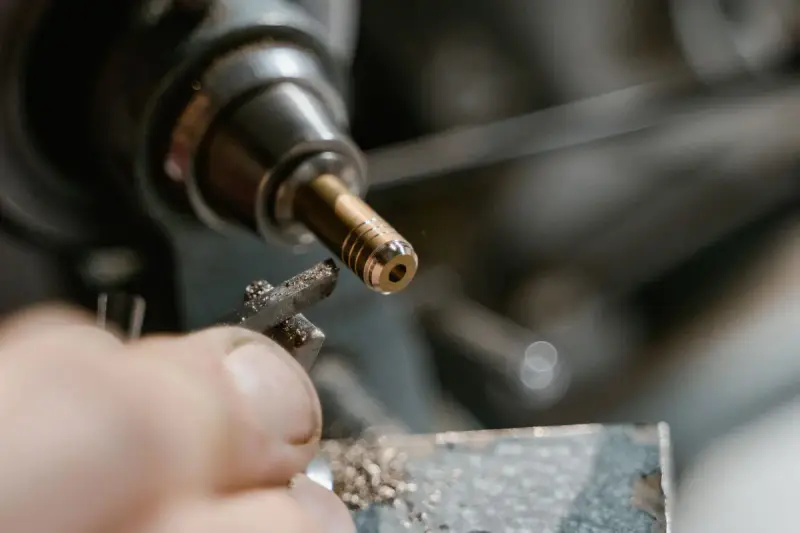 Threaded brass part spinning in a lathe as fine chips fall away