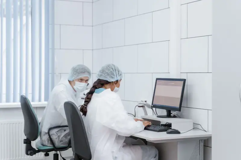 Two scientists analyzing data together at a computer in a laboratory