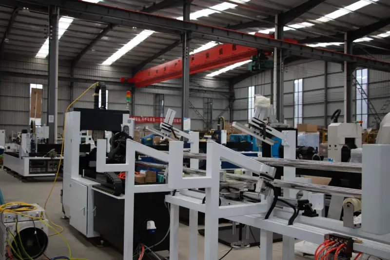 Production hall filled with white machine frames under an overhead crane