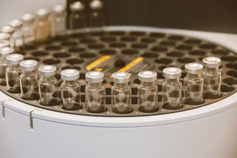Clear glass vials arranged in a round holder on a lab bench