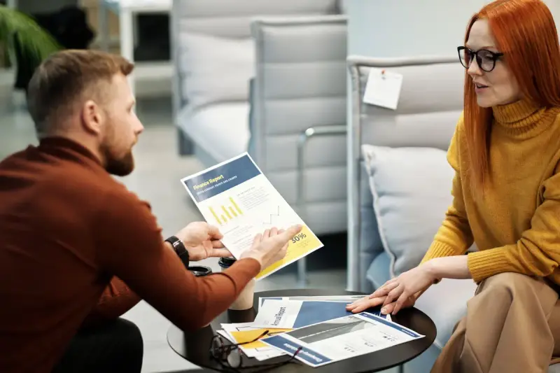 Man and woman reviewing a printed product sheet together in a meeting