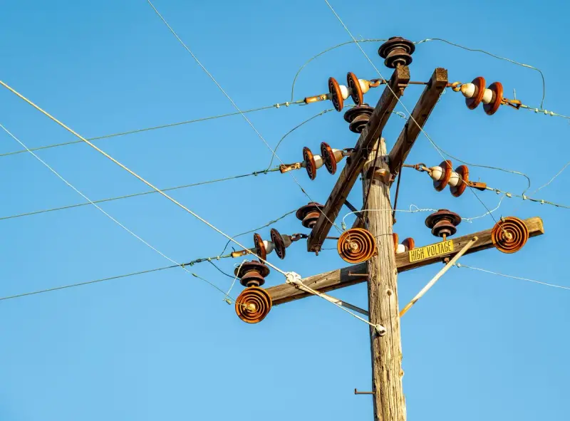 High-voltage power line hardware against a blue sky
