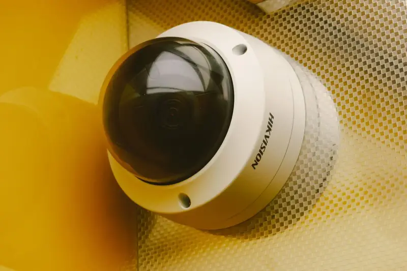 Modern security camera mounted on an interior wall, seen from below