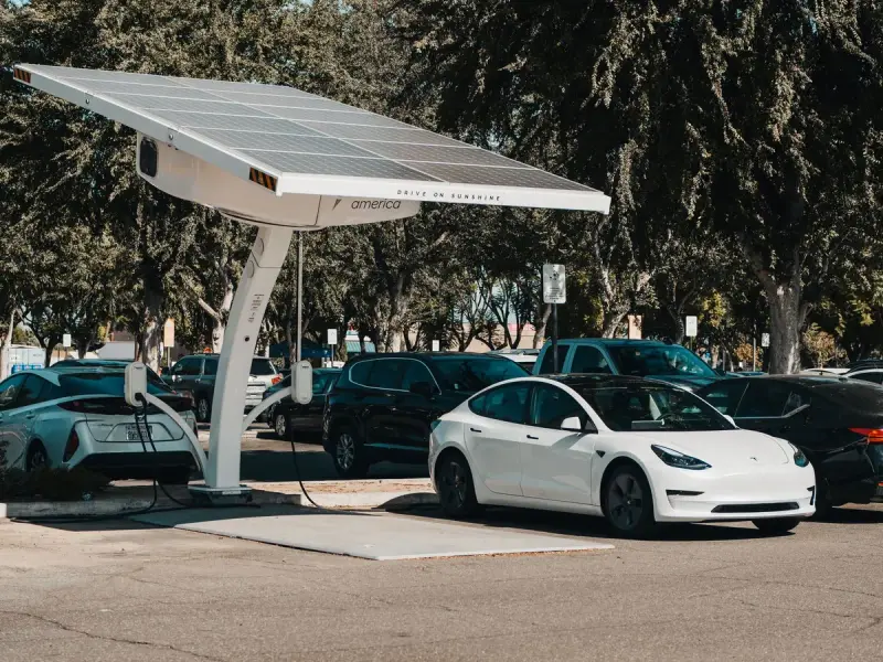 Electric car parked at an outdoor charging station under a solar canopy