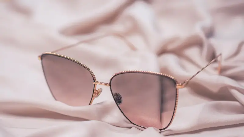 Rose-gold sunglasses resting on soft fabric