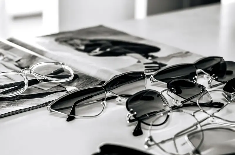 Black and white sunglasses arranged on a glossy magazine page