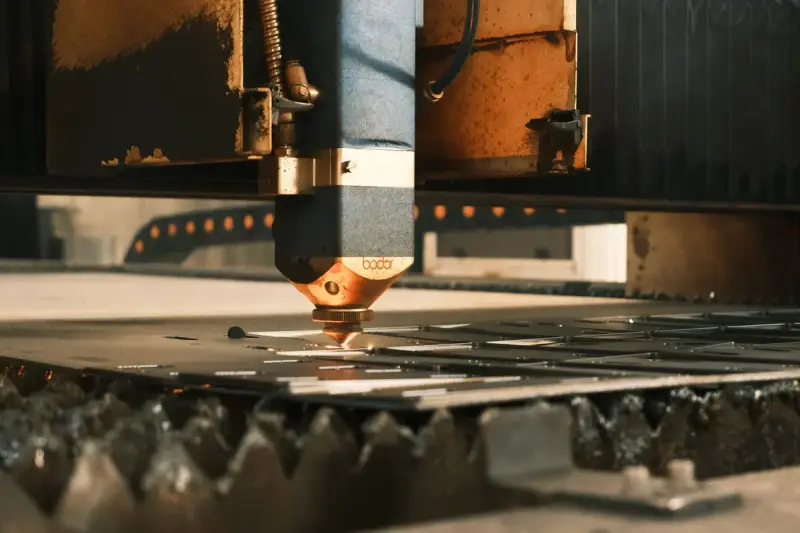 Laser cutter cutting sheet metal in an industrial facility