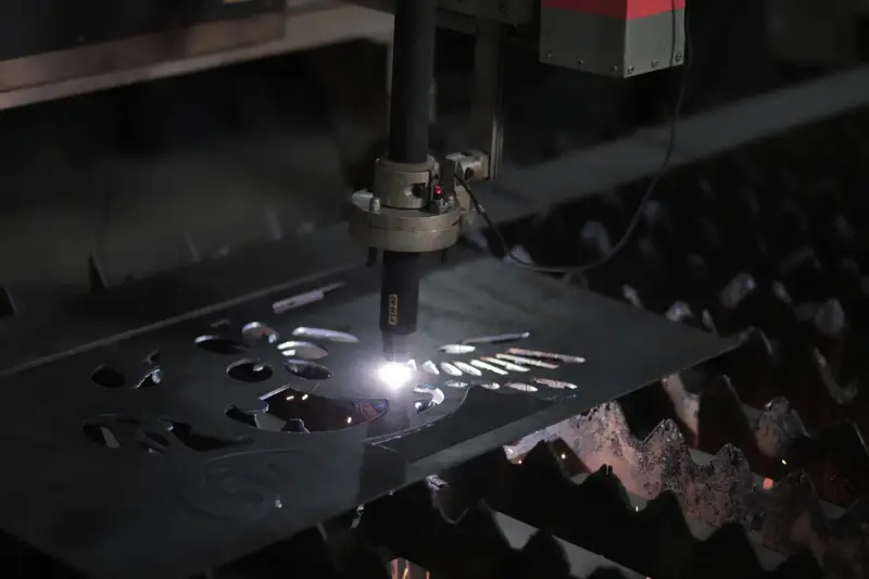 Plasma cutting machine working on a metal sheet in a factory