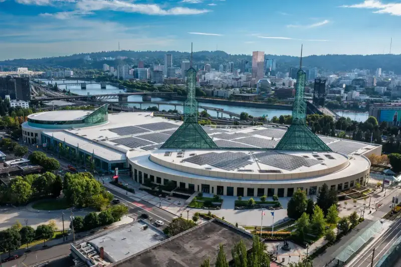 Aerial view of the Oregon Convention Center with the Portland skyline behind it